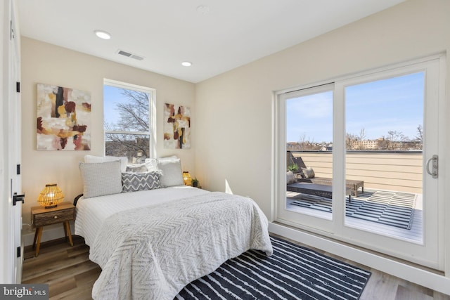 bedroom with recessed lighting, visible vents, wood finished floors, and access to exterior