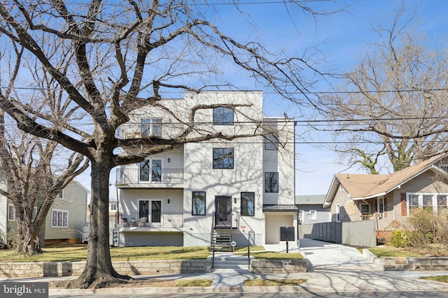 view of front of property with concrete driveway and a balcony