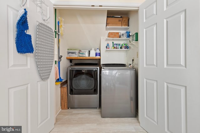 laundry room with wood finished floors and washing machine and clothes dryer