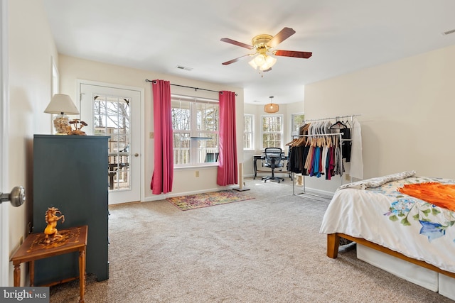 carpeted bedroom with a ceiling fan, access to exterior, baseboards, and visible vents