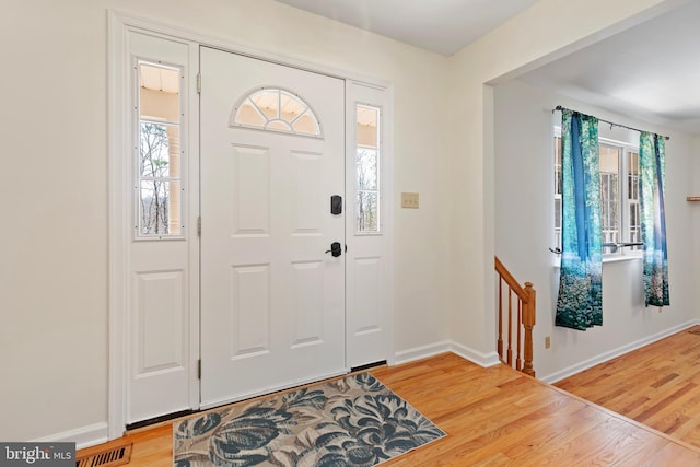 entrance foyer with visible vents, baseboards, and wood finished floors