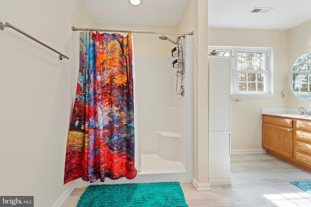 bathroom featuring visible vents, baseboards, a stall shower, and vanity