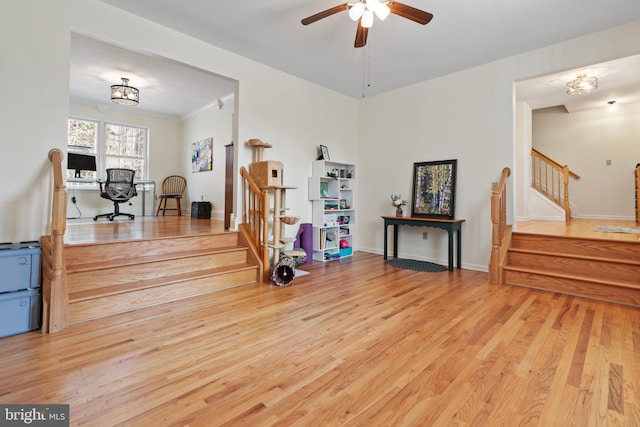 interior space with baseboards, wood finished floors, and a ceiling fan