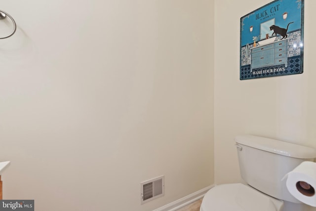 bathroom with vanity, toilet, baseboards, and visible vents