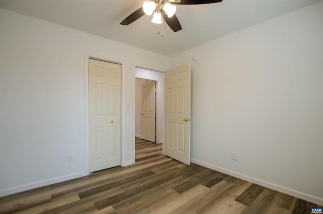 unfurnished bedroom with a ceiling fan, wood finished floors, and baseboards