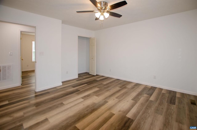 spare room with visible vents, baseboards, and wood finished floors