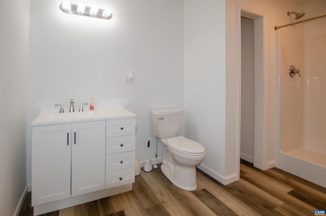 full bath with a shower, toilet, wood finished floors, and vanity