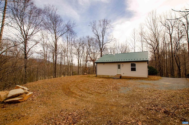 view of side of property featuring entry steps and metal roof