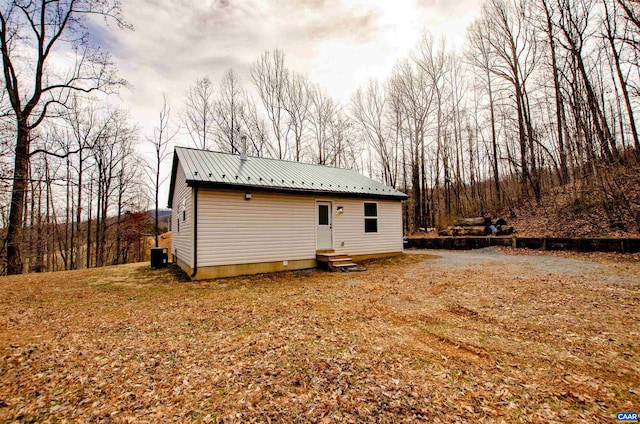 view of side of property featuring entry steps, metal roof, and central AC