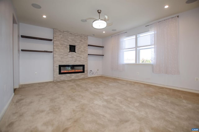 unfurnished living room with recessed lighting, carpet floors, and a fireplace