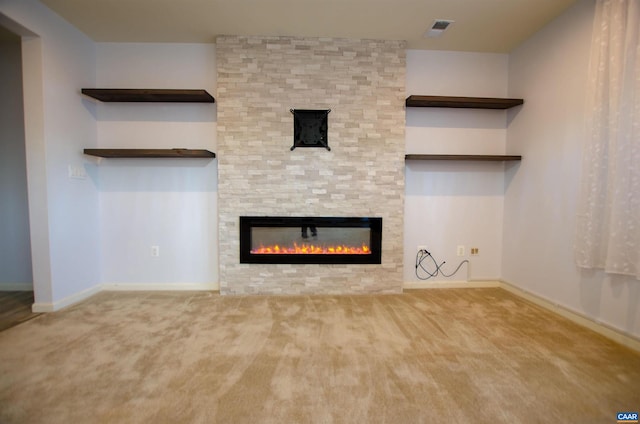 unfurnished living room with visible vents, baseboards, carpet, and a stone fireplace