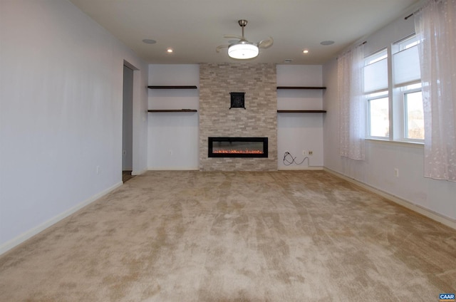 unfurnished living room featuring recessed lighting, a fireplace, baseboards, and carpet