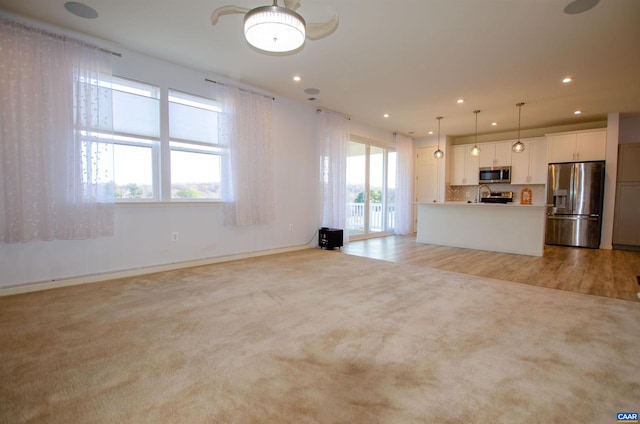 unfurnished living room featuring recessed lighting and light carpet