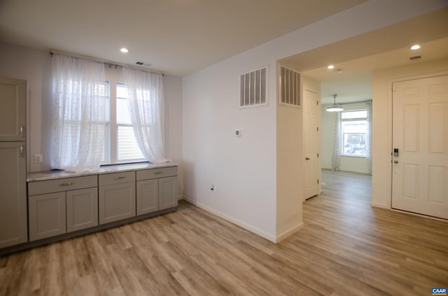 interior space with recessed lighting, visible vents, light wood-style flooring, and baseboards