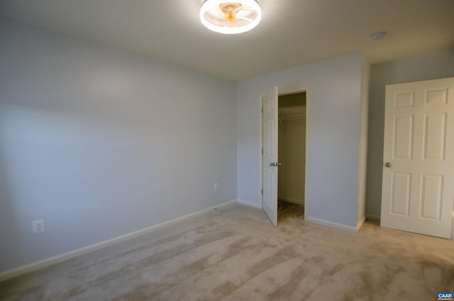 unfurnished bedroom featuring light colored carpet, baseboards, and a closet