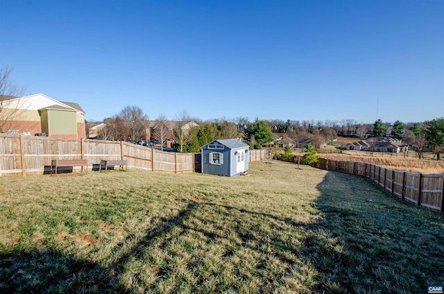 view of yard with a storage shed, an outbuilding, and a fenced backyard