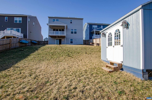 rear view of property featuring a yard and fence