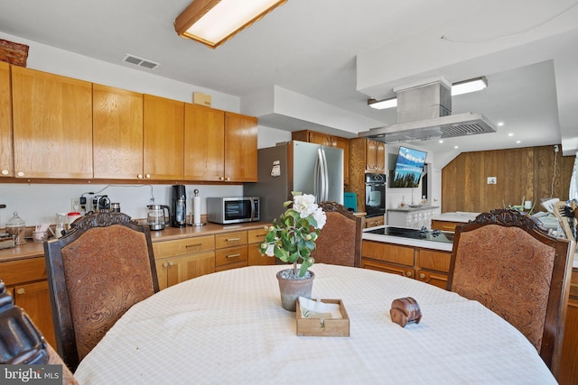 kitchen featuring visible vents, black appliances, range hood, and light countertops