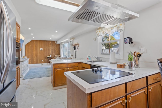 kitchen featuring open floor plan, a peninsula, exhaust hood, marble finish floor, and black appliances