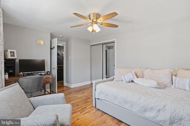 bedroom featuring a closet, ceiling fan, baseboards, and light wood-style floors