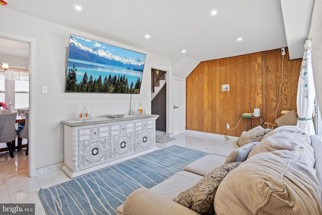 living room with recessed lighting, marble finish floor, baseboards, and wood walls