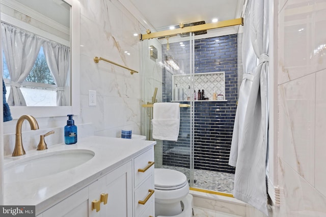 bathroom featuring a shower stall, crown molding, toilet, vanity, and tile walls