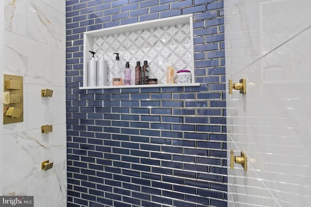 interior details featuring tiled shower