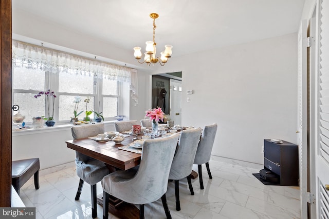 dining room featuring marble finish floor and an inviting chandelier