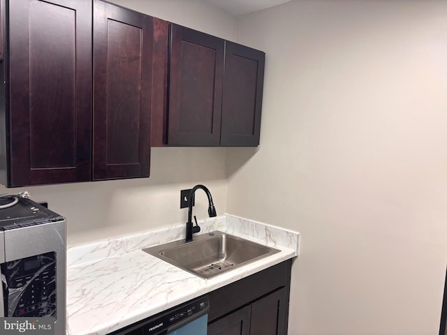 kitchen featuring dark brown cabinetry, dishwashing machine, light countertops, and a sink