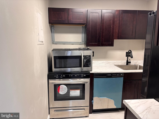 kitchen featuring oven, a sink, stainless steel microwave, dark brown cabinetry, and dishwasher