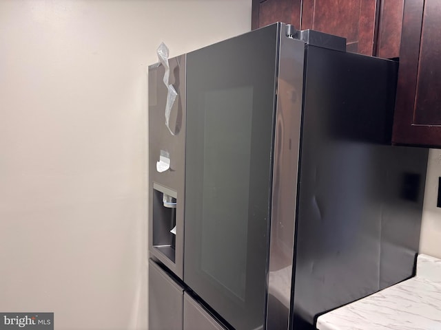 room details featuring dark brown cabinetry and fridge