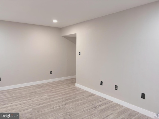 empty room featuring recessed lighting, light wood-style flooring, and baseboards