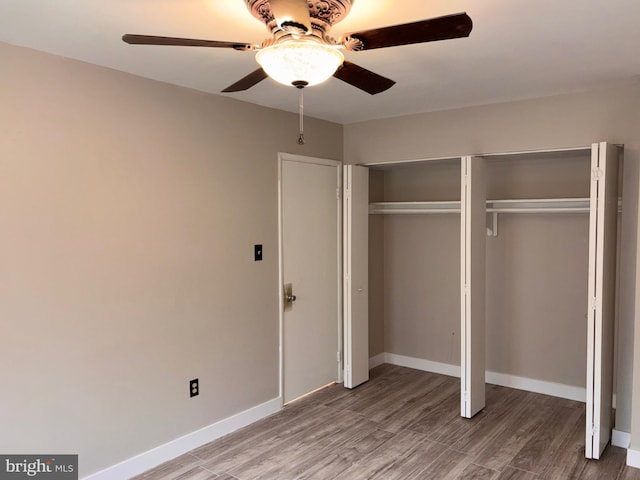 unfurnished bedroom featuring light wood finished floors, a closet, a ceiling fan, and baseboards