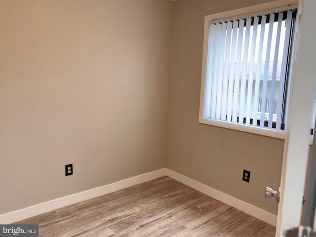 unfurnished room featuring baseboards and light wood-style flooring