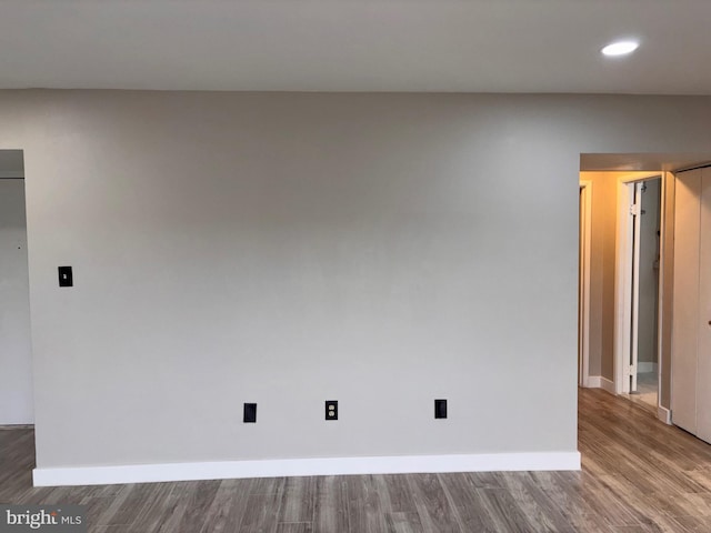 unfurnished room featuring recessed lighting, baseboards, and wood finished floors