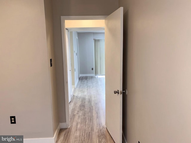 hallway with baseboards and light wood-style floors