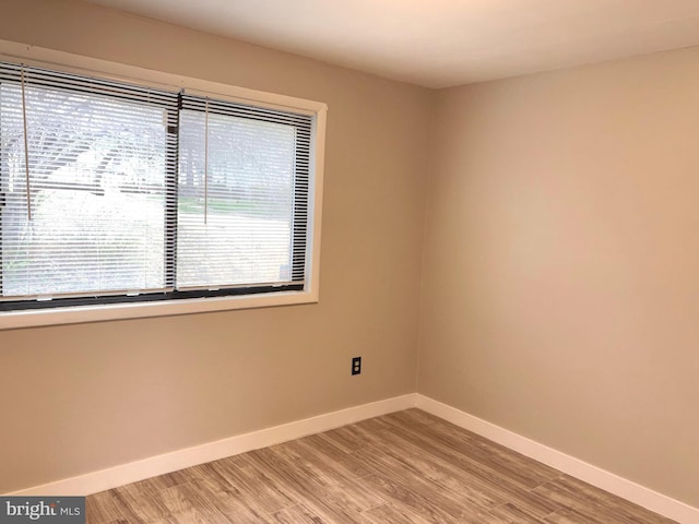 empty room with baseboards and light wood finished floors