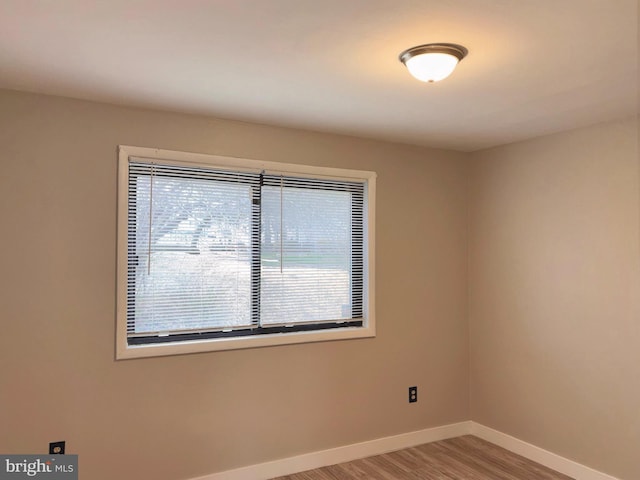 spare room with light wood-style floors and baseboards