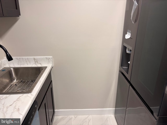 laundry area with a sink, baseboards, and marble finish floor