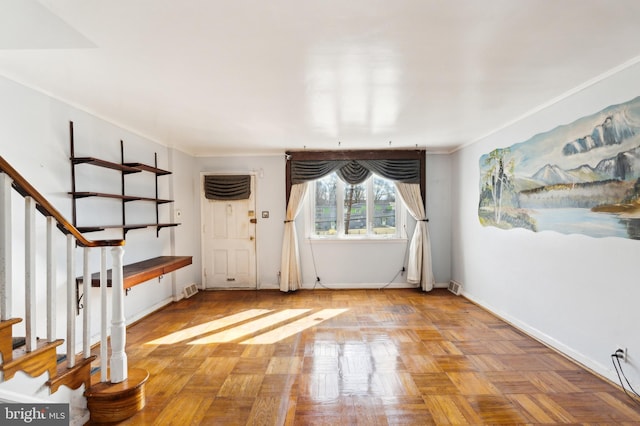 foyer featuring stairway, ornamental molding, baseboards, and a wall mounted AC