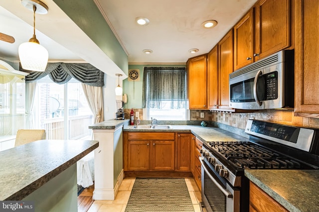 kitchen featuring brown cabinets, appliances with stainless steel finishes, and a sink