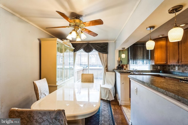 dining room with a ceiling fan and ornamental molding