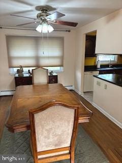 dining area featuring a baseboard heating unit, dark wood-type flooring, and ceiling fan