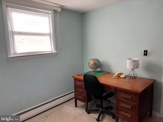 office space featuring a baseboard heating unit and baseboards