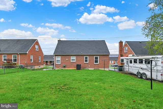 back of property featuring a yard, a fenced backyard, brick siding, and central air condition unit