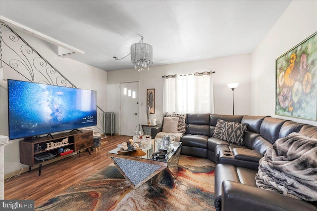 living area featuring stairs, an inviting chandelier, wood finished floors, and radiator heating unit