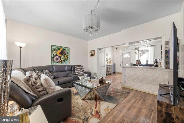 living area with a notable chandelier and wood finished floors