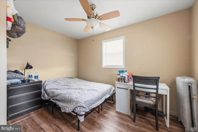 bedroom featuring radiator, a ceiling fan, and wood finished floors