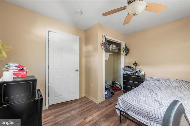 bedroom with a ceiling fan, wood finished floors, and baseboards