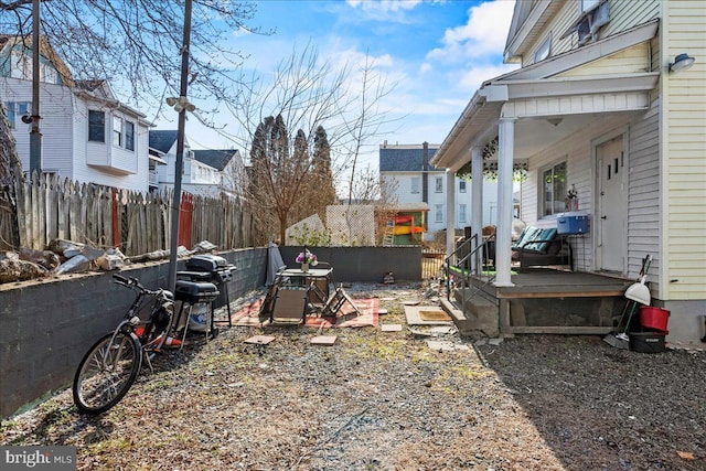 view of yard featuring fence and covered porch